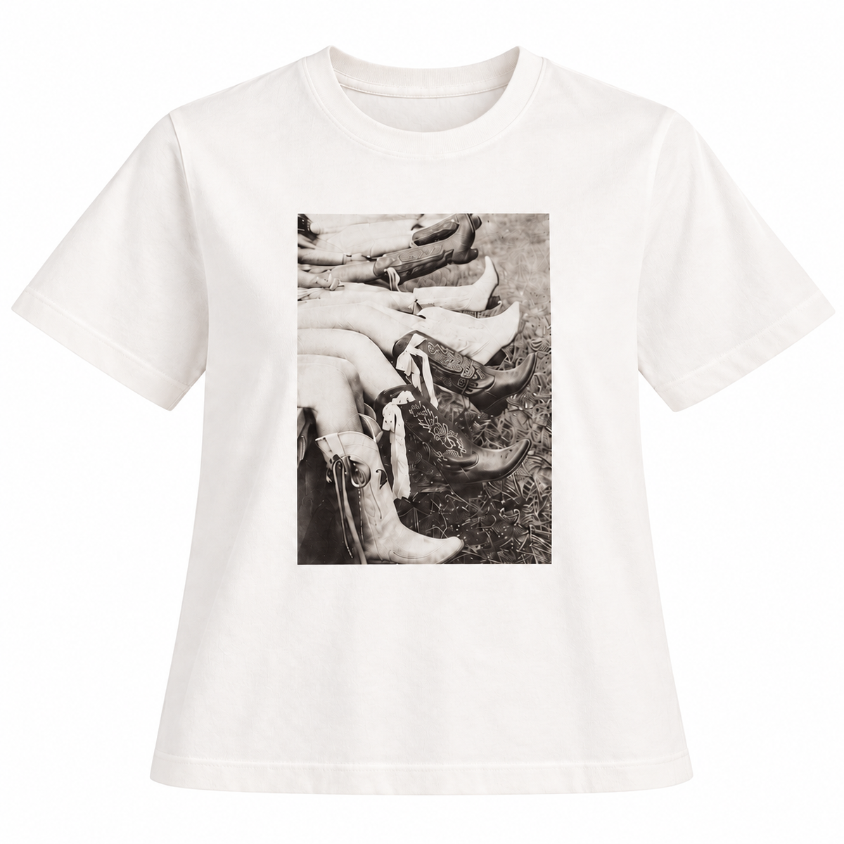 An off-white short-sleeve t-shirt with a black and white graphic print of cowboy boots and legs, displayed on a clean white background.
