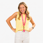 Model wearing a bright pink scrunchie lanyard with a yellow sun pattern and antique-brass-tone hardware.