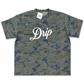 A short-sleeve crewneck t-shirt featuring a green and blue camouflage pattern with the word 'Drip' printed in white script across the chest. A white brand tag for 'Casual' is visible inside the collar.