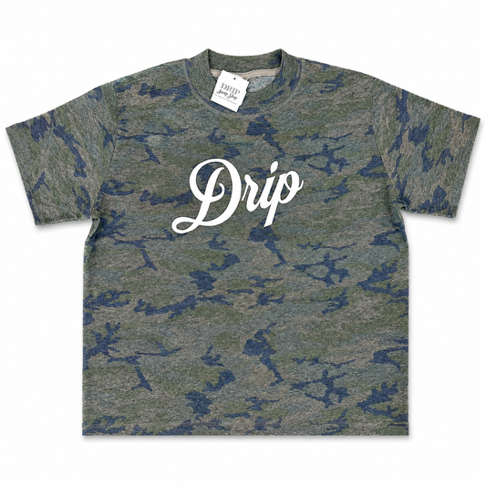 A short-sleeve crewneck t-shirt featuring a green and blue camouflage pattern with the word 'Drip' printed in white script across the chest. A white brand tag for 'Casual' is visible inside the collar.