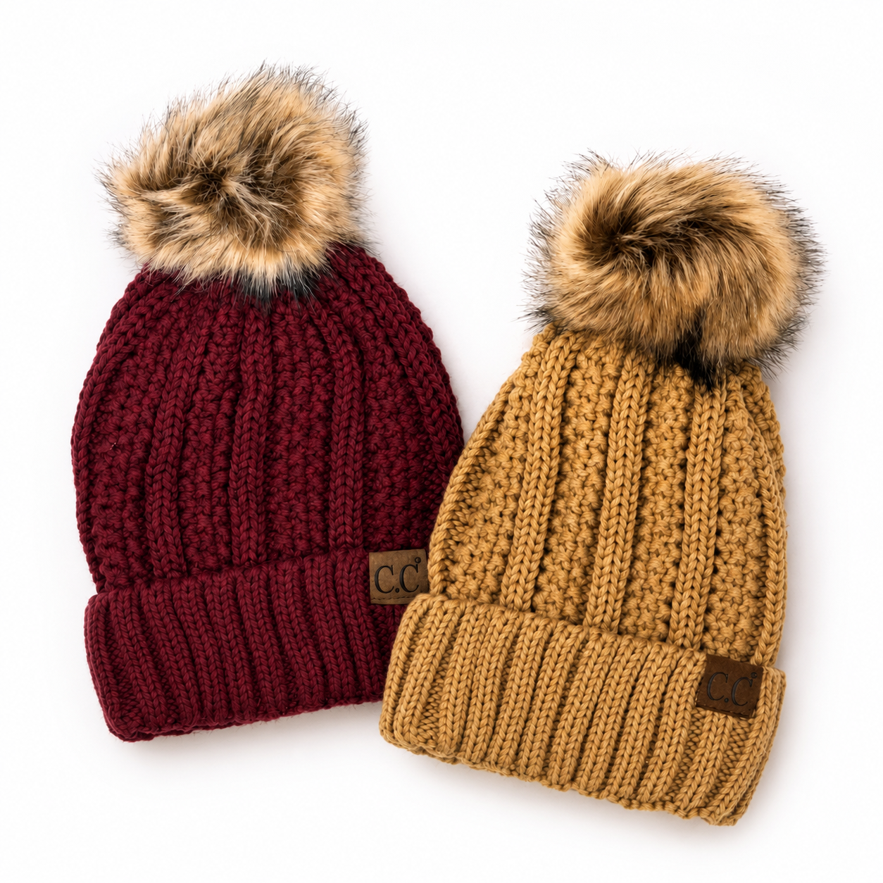 Maroon and camel sherpa-lined knit beanies with faux fur poms and C.C. logo patches