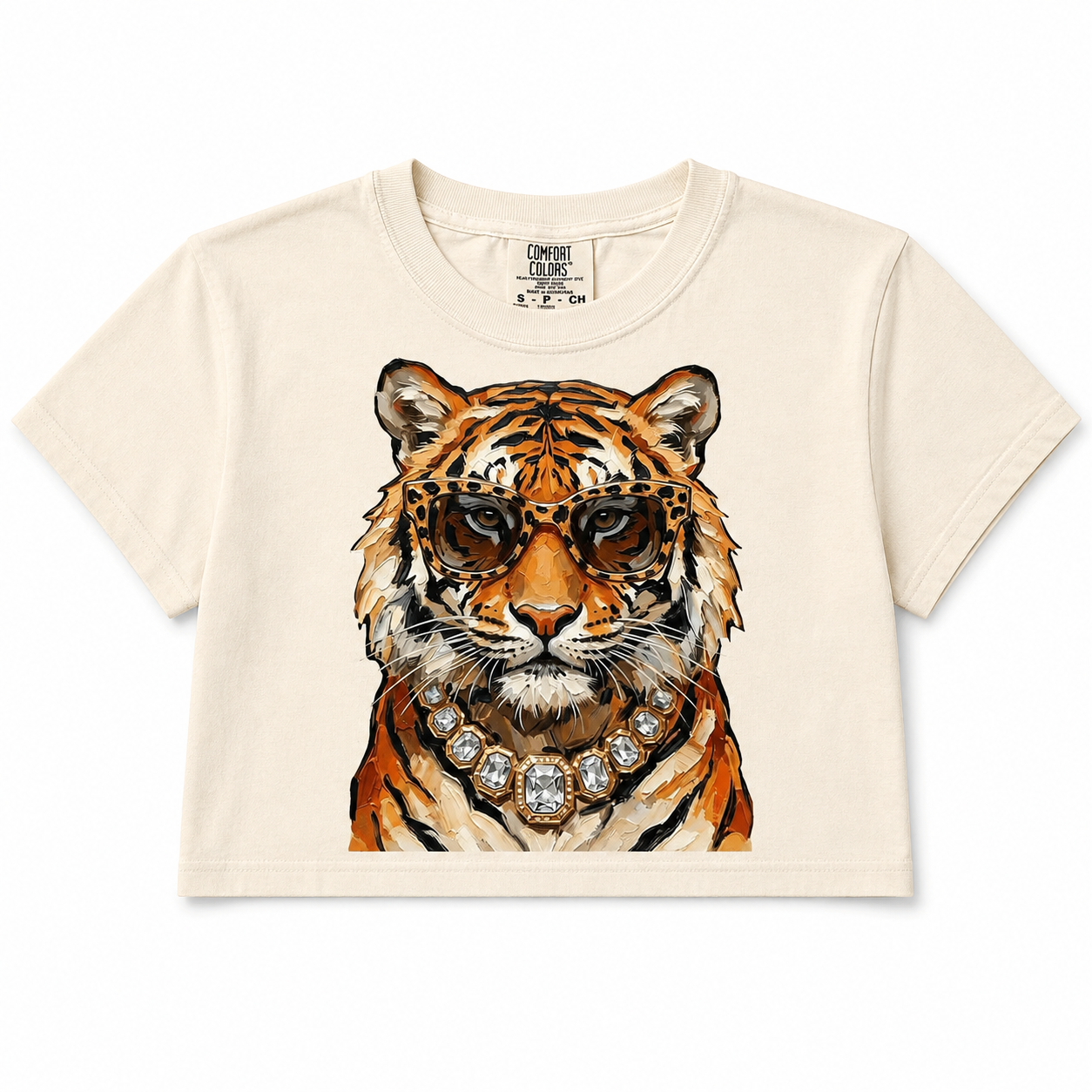 Full image: Cream cropped T-shirt featuring a tiger in tortoiseshell glasses and a crystal statement necklace.