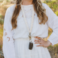 Close-up of a cream Oat Milk scrunchie lanyard with antique-brass-tone hardware and an attached car key.