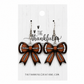 Football bow earrings in brown, black, and white on a white display card
