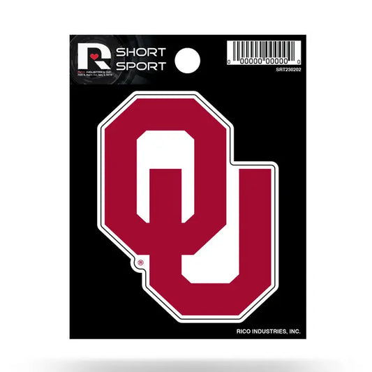 A Short Sport Oklahoma Sooners decal on a black backing card. The decal features a large maroon 'OU' logo with a white border, and the backing card includes a barcode and the Short Sport brand logo.