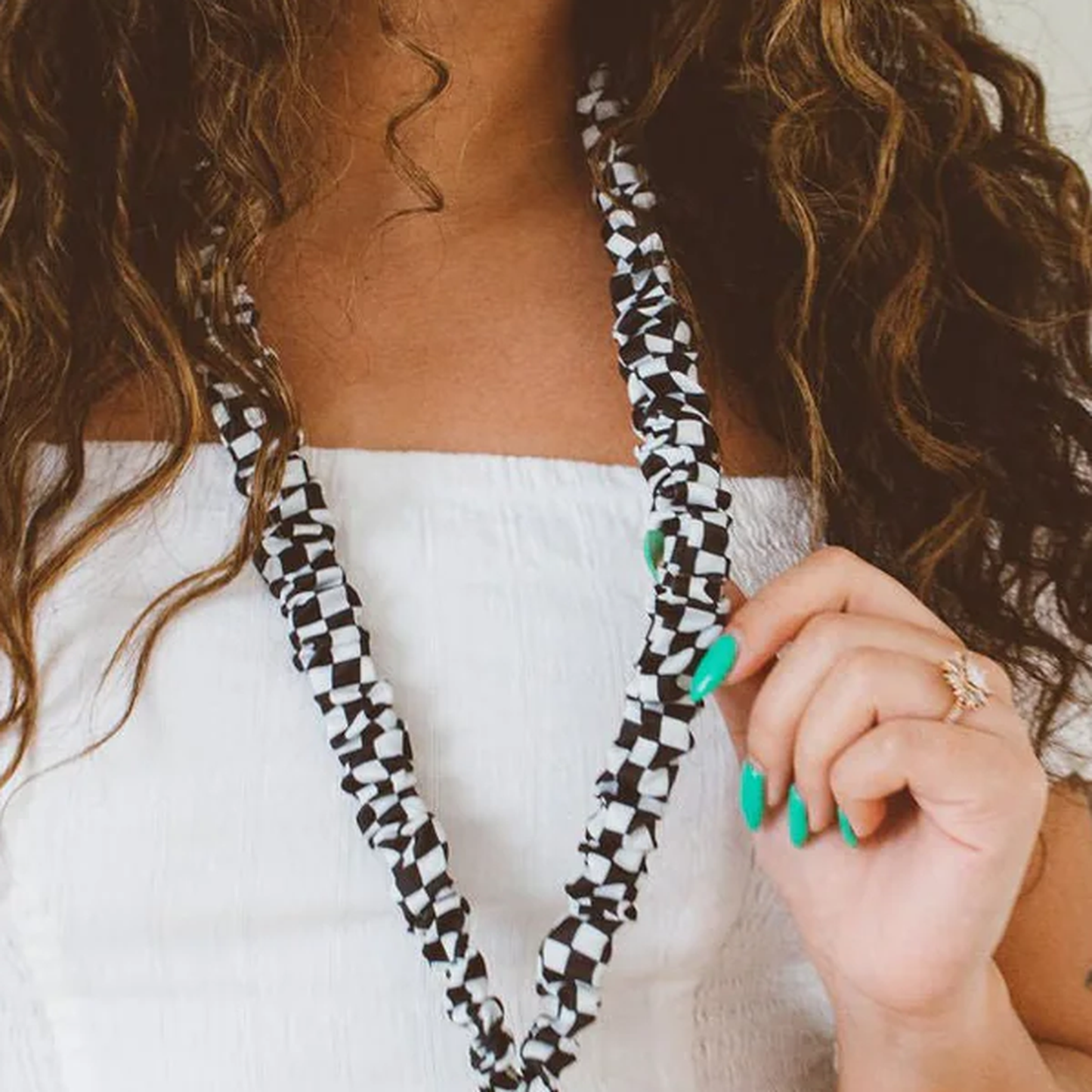 Close-up of black checkerboard lanyard showing the fabric pattern and hardware