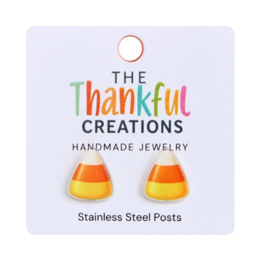 Candy corn stud earrings with cream, orange, and yellow stripes on a white jewelry display card.