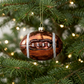 Copper football ornament hanging on a Christmas tree
