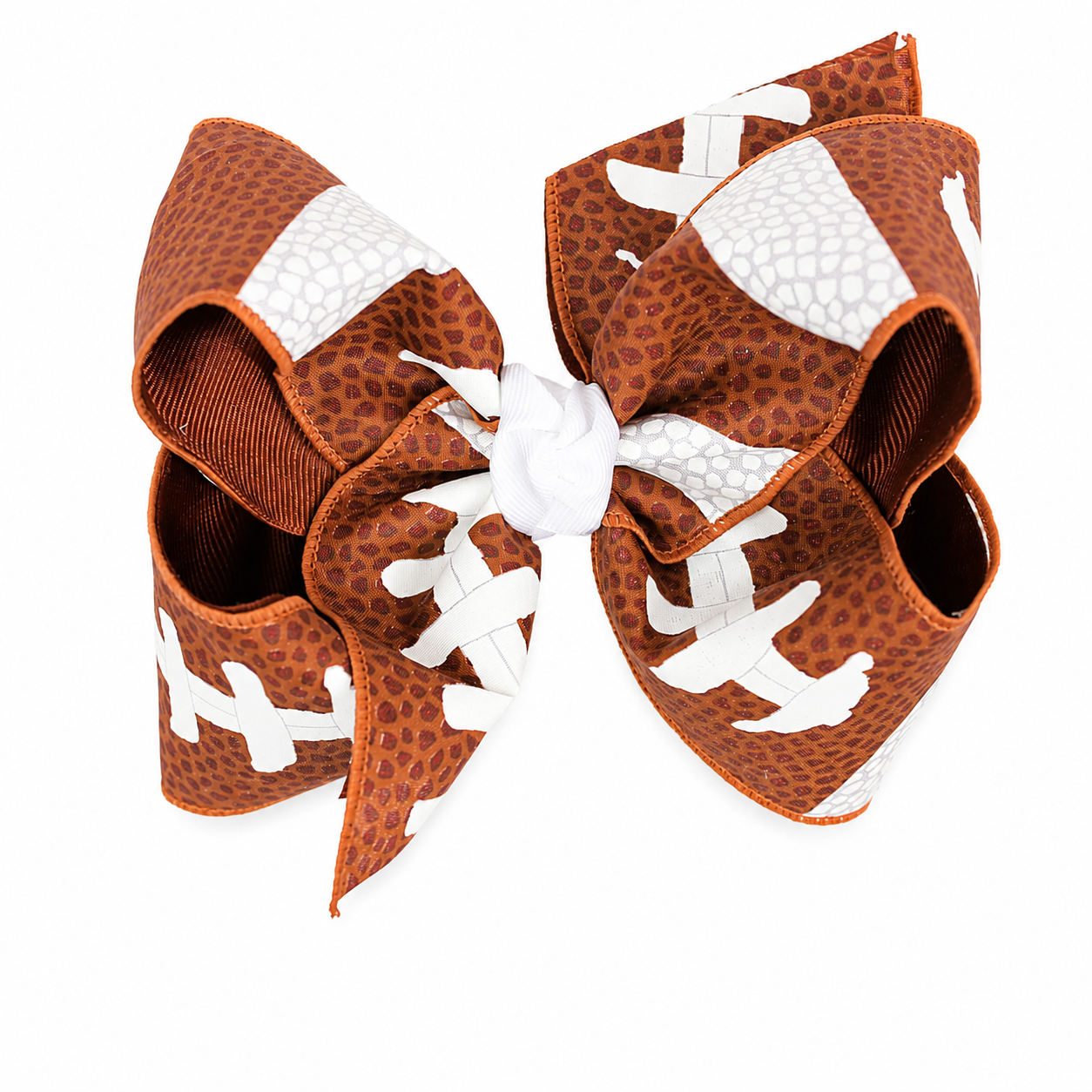 A large hair bow designed in the style of a football, featuring a brown and white textured pattern with white laces and a white center, shown on a plain white background.