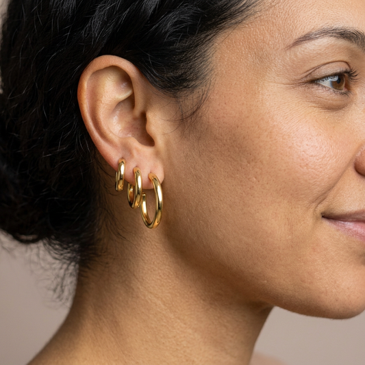 Graduated textured gold hoops worn in three lobe piercings