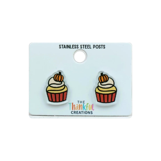 Pumpkin cupcake stud earrings displayed on a white jewelry card.