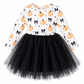 A toddler girl's long-sleeve dress with a white bodice printed with orange pumpkins, black bows, and small black stars, paired with a full black tulle tutu skirt, shown on a plain white background.