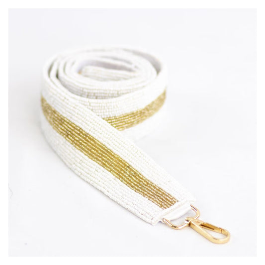 White and gold beaded purse strap coiled on a white background with gold-tone clasp